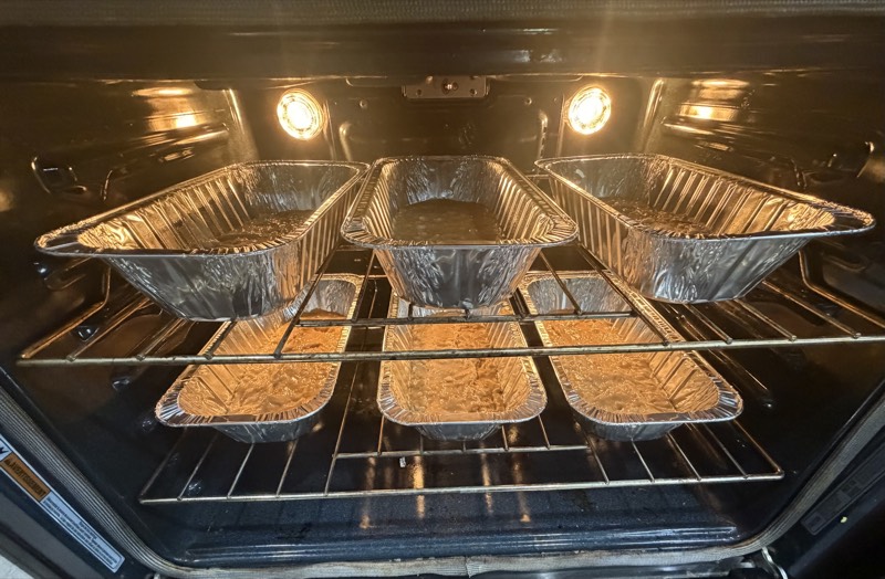 Loaf pans of banana bread baking in an oven